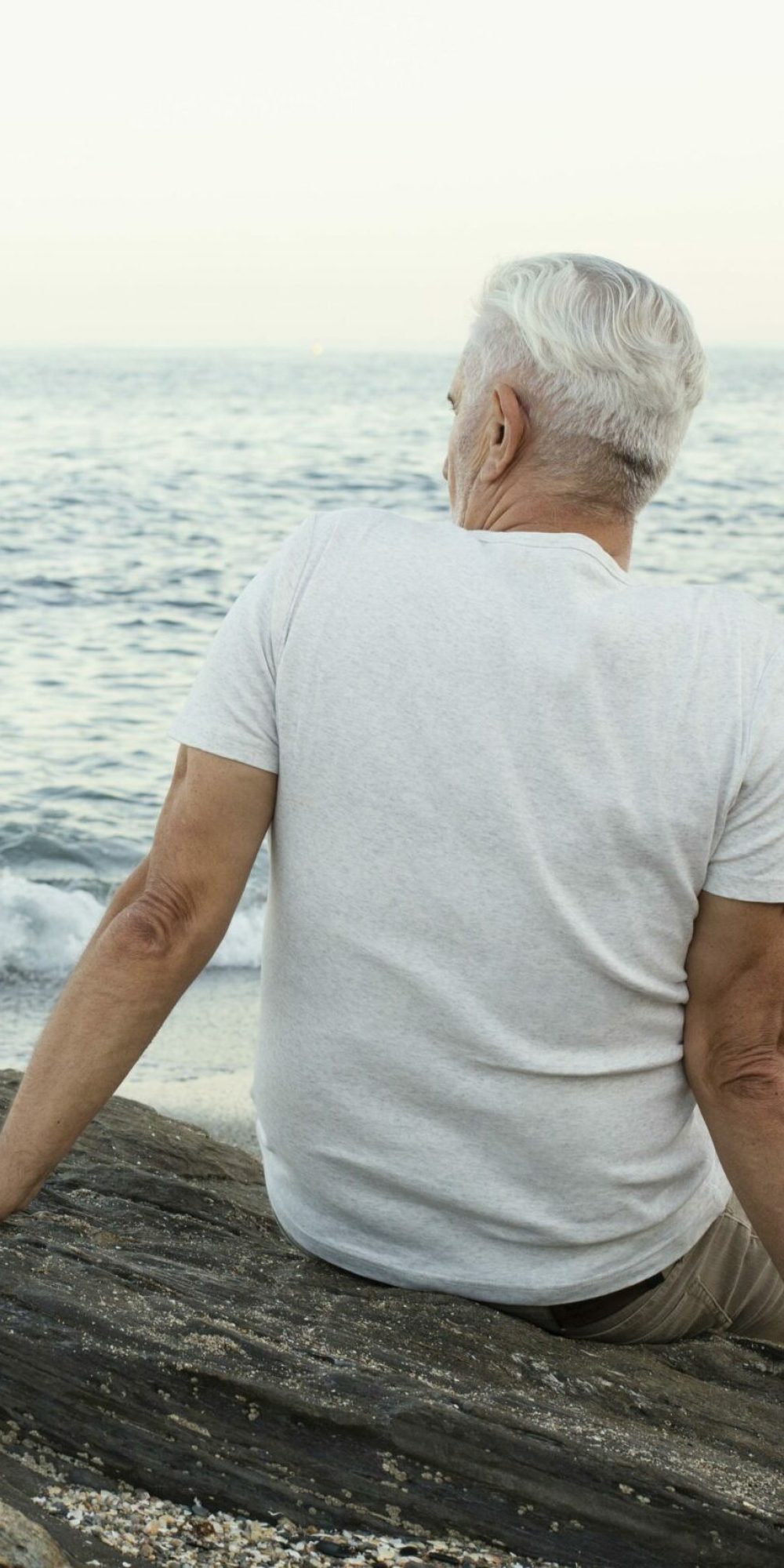 senior-man-resting-beach-admiring-ocean